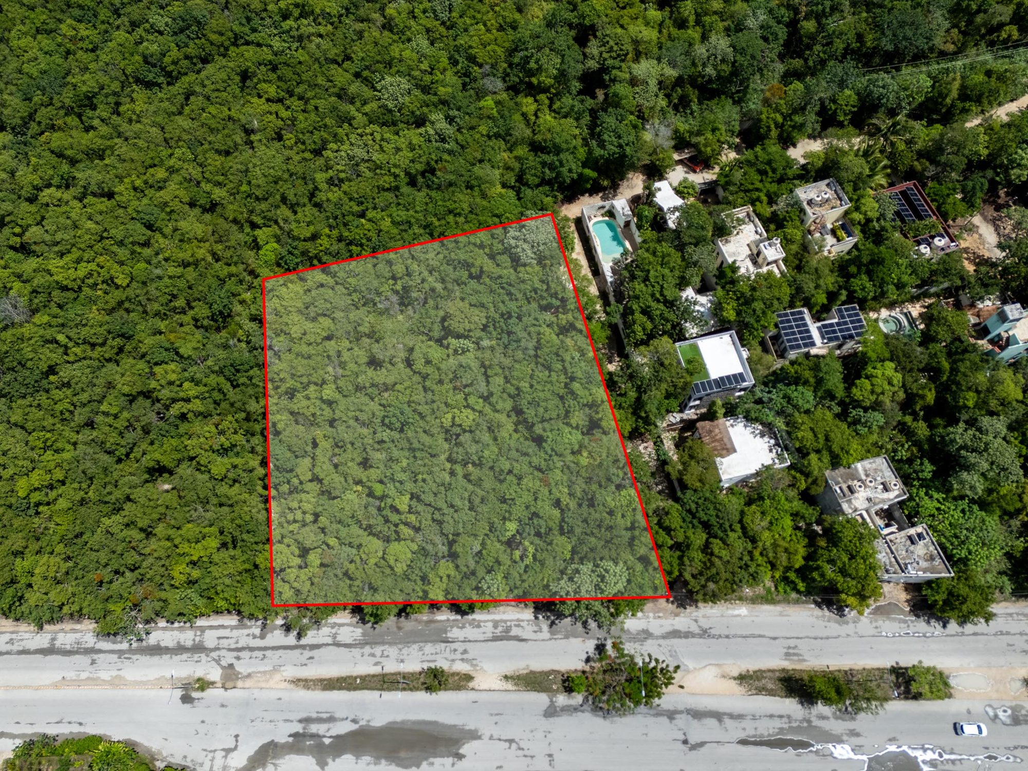 Top-down drone view of the lot outline beside neighboring homes