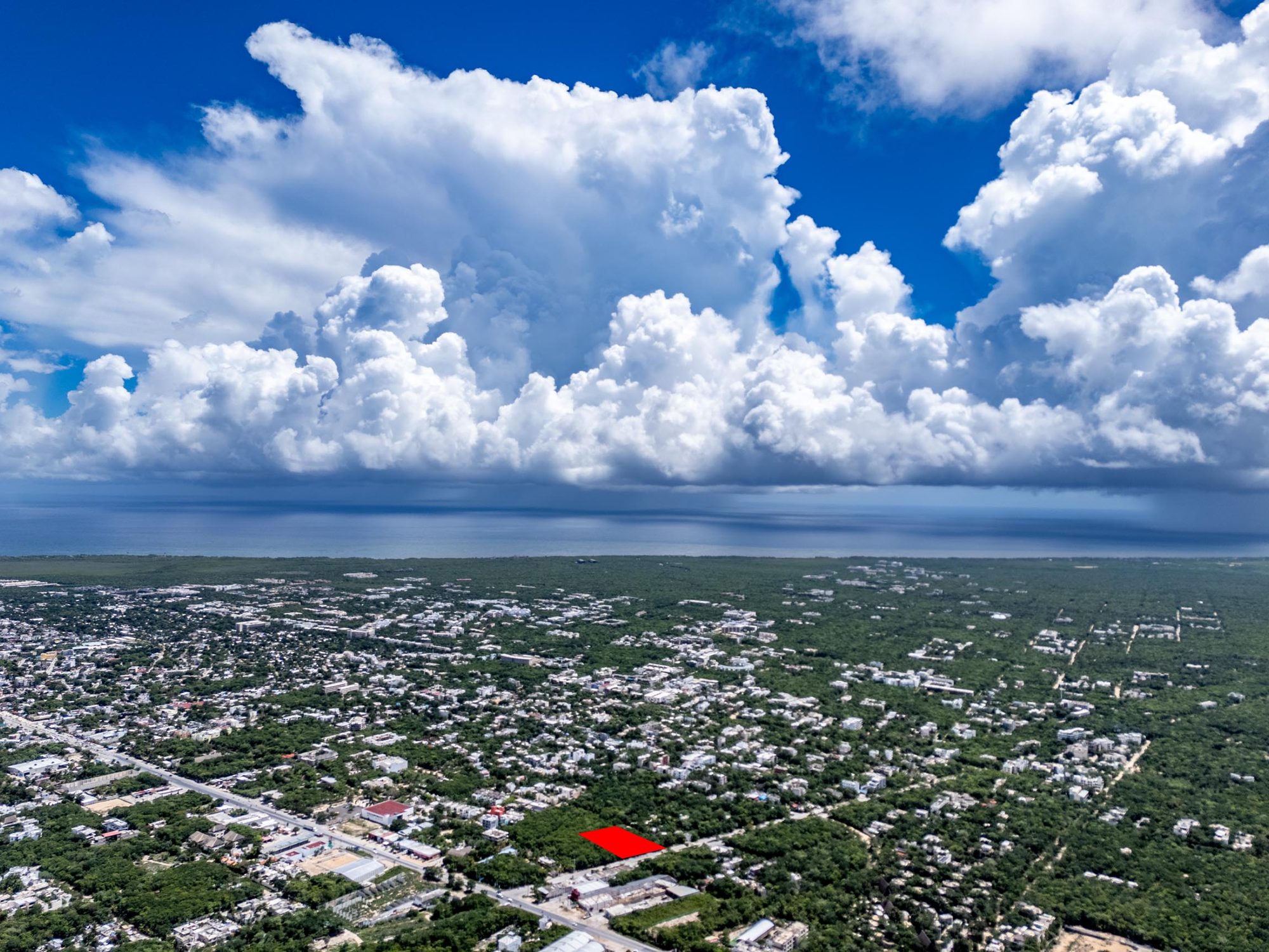 High-altitude view of Tulum toward the Caribbean with the lot marked in red