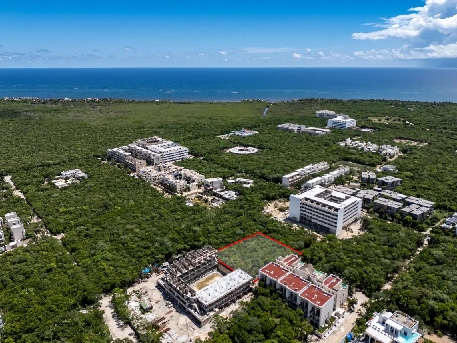 Aerial view over La Veleta toward the Caribbean, with Lot 644 outlined in red between new residential buildings
